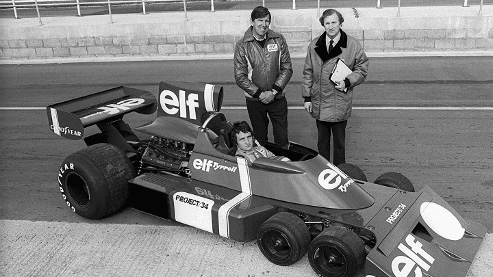 Patrick Depailler au volant de la Tyrrell P34 à six roues à Silverstone en 1975, entouré de Ken Tyrrell et du concepteur Derek Gardner