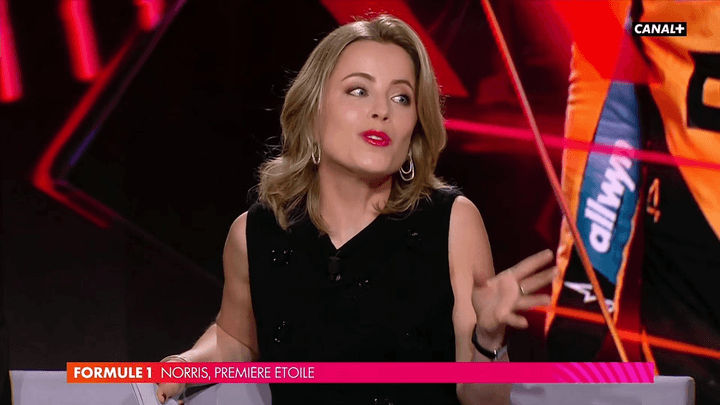 Pauline Sanzey présentant l'émission Formule 1 sur Canal+ dans un décor rouge avec le logo de la chaîne
