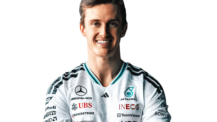 Théo Pourchaire en combinaison Mercedes F1, souriant et posant les bras croisés