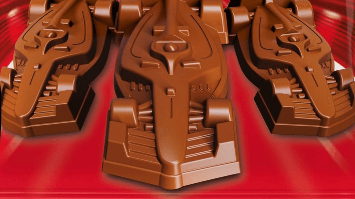 Mini-voitures de Formule 1 en chocolat KitKat alignées sur fond rouge