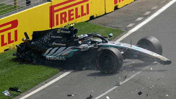 Voiture de Formule 1 Mercedes accidentée et fumante sur l'herbe après un crash sur le circuit
