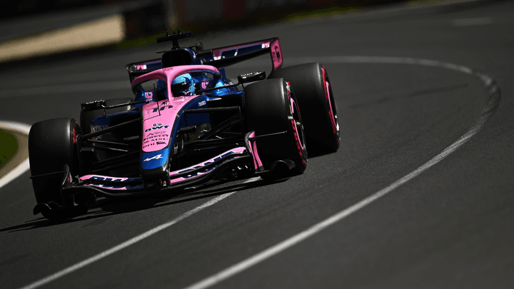 Monoplace Alpine F1 bleue et rose en action sur le circuit