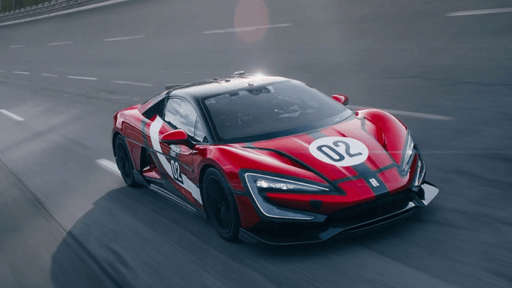 Voiture de course rouge et noire en action sur circuit de Formule 1