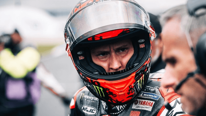 Portrait de Fabio Quartararo en casque et combinaison de pilote avec regard déterminé