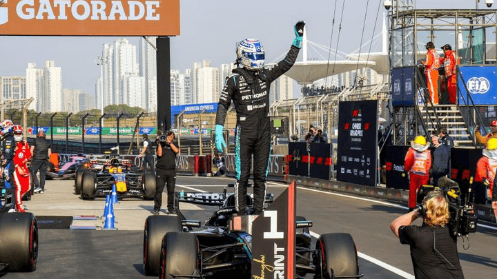 Pilote de F1 célébrant sa victoire sur le podium en levant les bras