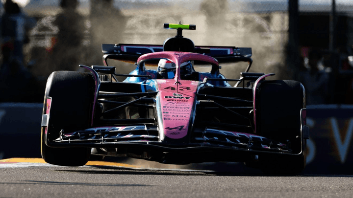 Voiture de Formule 1 rose et noire en action sur le circuit