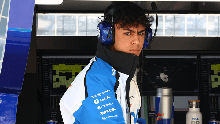 Arvid Lindblad assis dans les stands du paddock, fronçant les sourcils