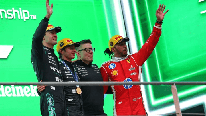 Podium F1 avec trois pilotes célébrant leur victoire, levant leurs trophées