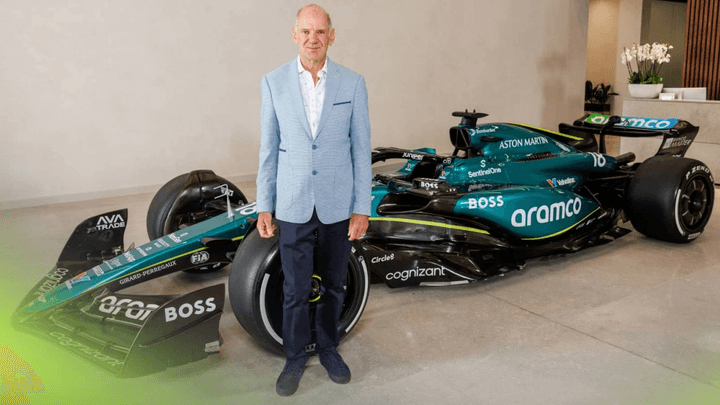 Adrian Newey en costume posant devant une monoplace Aston Martin F1 verte