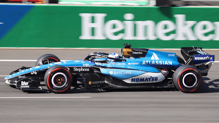 Voiture Williams F1 bleue en action sur circuit avec sponsor Heineken visible