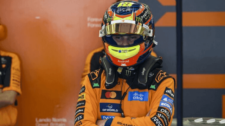 Piastri dans le paddock avec son casque McLaren croisant les bras