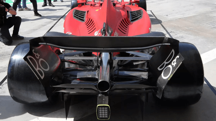 Vue arrière d'une Ferrari de Formule 1 rouge montrant l'aileron arrière et les éléments aérodynamiques