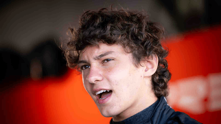 Pilote F2 souriant en combinaison Puma avec logo Formula 2 Championship visible