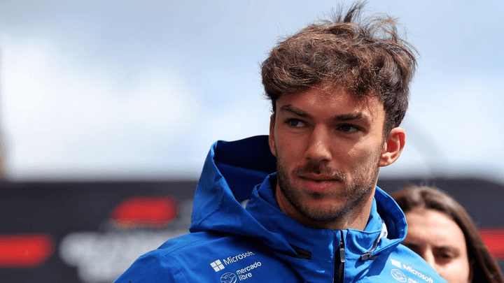 Pilote de Formule 1 en tenue bleue d'équipe lors d'un événement paddock