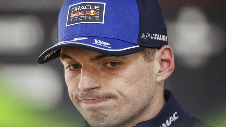 Portrait de Max Verstappen en combinaison Red Bull avec une expression pensive