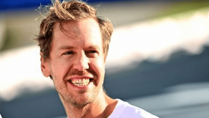 Sebastian Vettel souriant en t-shirt blanc lors d'un événement F1