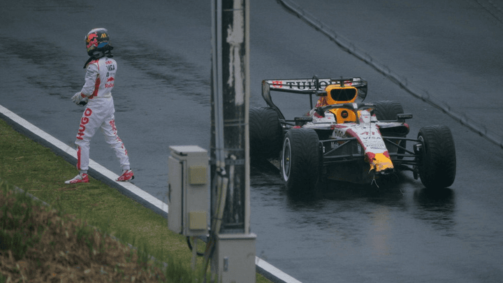 Pilote de F1 s'éloignant de sa monoplace Red Bull sur piste mouillée après un incident