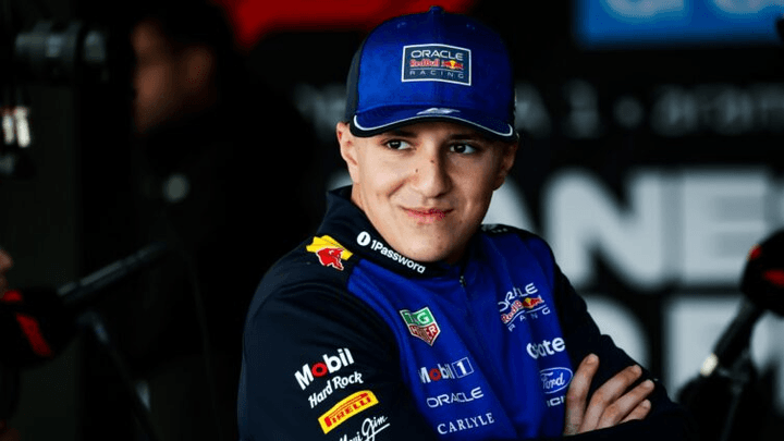 Pilote Red Bull Racing en combinaison bleue Oracle et casquette dans le paddock F1
