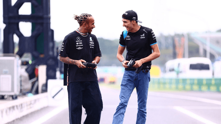 Lewis Hamilton et Esteban Ocon marchent ensemble sur le circuit avec une voiture RC F1