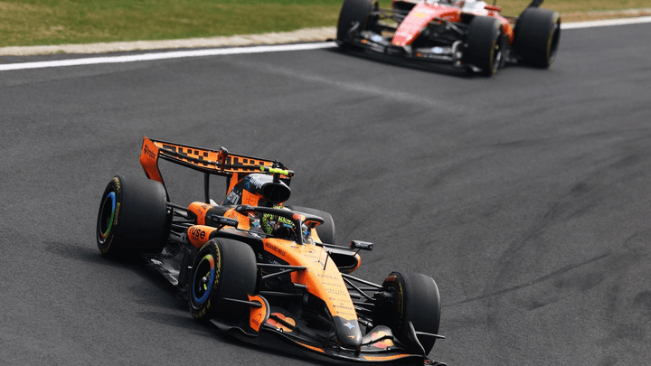 Monoplace McLaren orange en piste devant une Haas lors d'une session F1