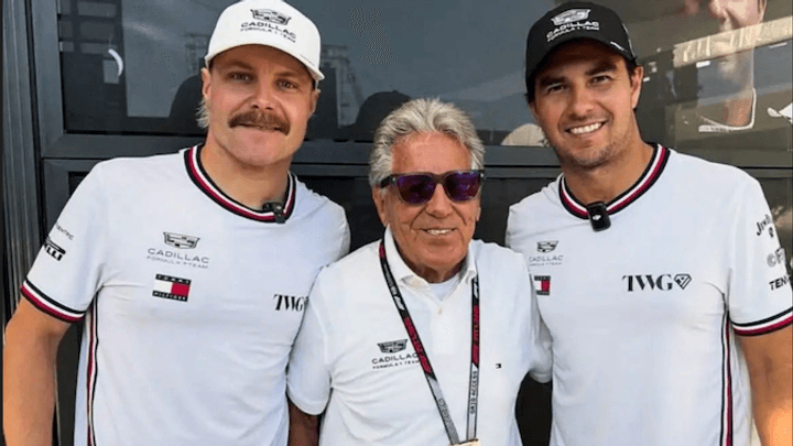 Trois hommes posant ensemble en tenues Cadillac F1, dont un dirigeant âgé au centre