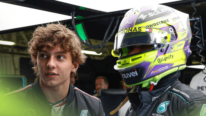 Andrea Kimi Antonelli en combinaison Mercedes dans le garage, regardant vers la caméra avec son casque à la main