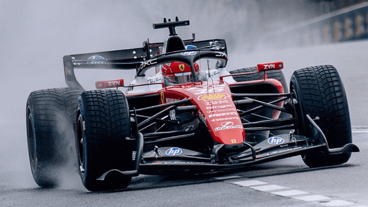 Voiture de F1 Ferrari roulant sous la pluie avec projections d'eau