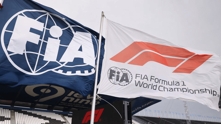 Drapeaux FIA et Formule 1 flottant sur un circuit lors d'un Grand Prix