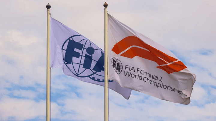 Drapeaux de la FIA et de la F1 flottant sous un ciel nuageux