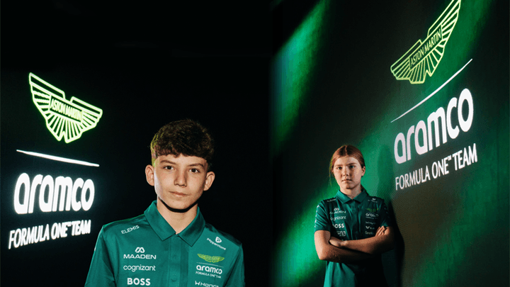 Deux jeunes pilotes en combinaison Aston Martin lors d'une présentation officielle de l'équipe