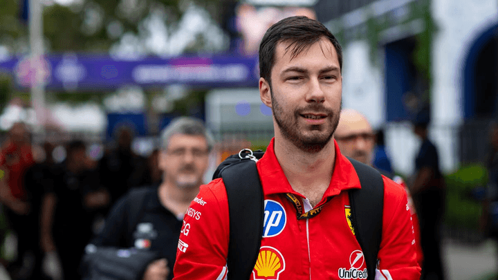 Pilote Ferrari en combinaison rouge avec sponsors Shell et Velas dans le paddock F1