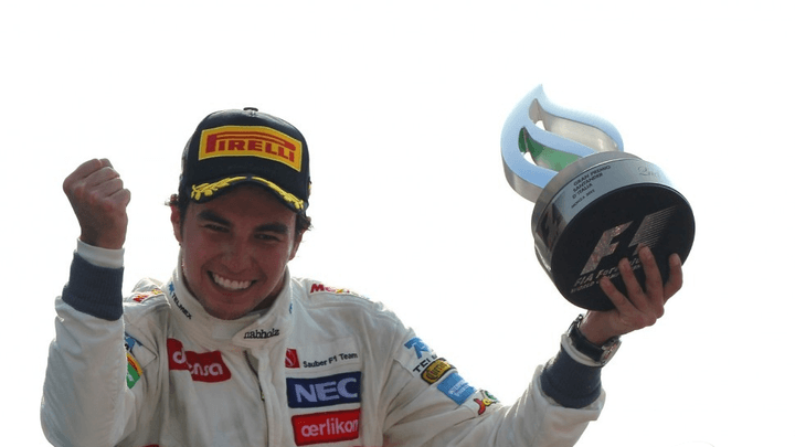 Sergio Pérez célèbre sur le podium avec son trophée et le poing levé
