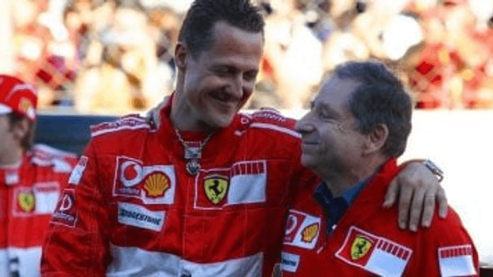 Michael Schumacher et Jean Todt célèbrent en combinaison Ferrari rouge sur le podium
