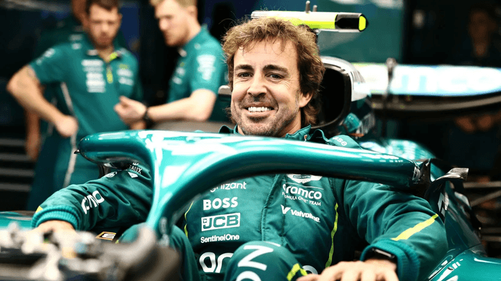 Fernando Alonso souriant dans son cockpit Aston Martin vert lors d'une séance F1