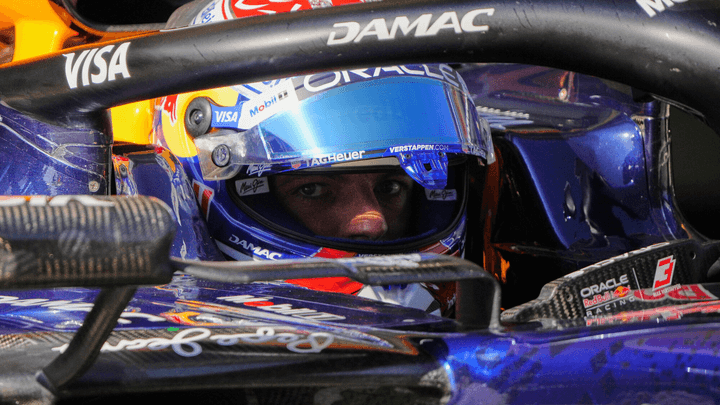 Gros plan d'un pilote de F1 dans son cockpit avec casque et harnais de sécurité visible