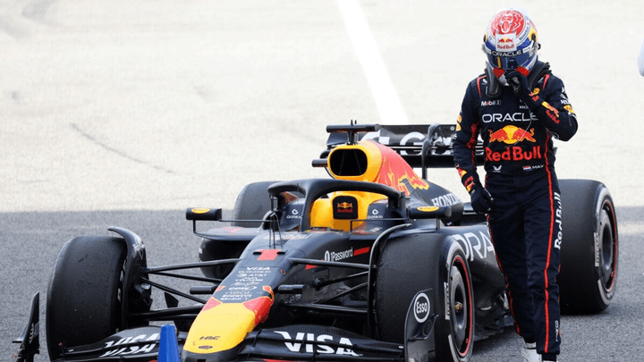 Max Verstappen debout près de sa Red Bull RB19 arrêtée sur circuit avec cône bleu