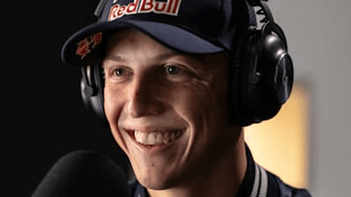 Pilote Red Bull souriante avec casque audio et casquette lors d'un interview