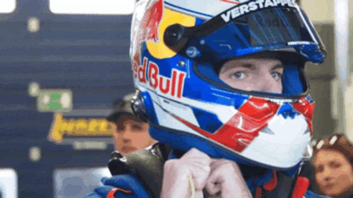 Pilote Red Bull Racing avec casque bleu, blanc et rouge dans le paddock F1