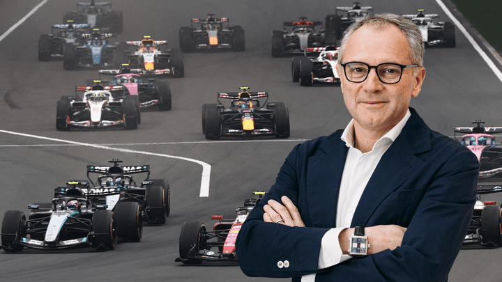 Stefano Domenicali, PDG de la Formule 1, devant des voitures de F1 en action sur circuit