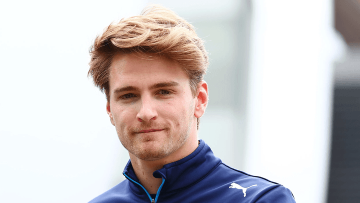 Pilote de F1 en tenue d'équipe bleue avec logo Puma lors d'un événement paddock