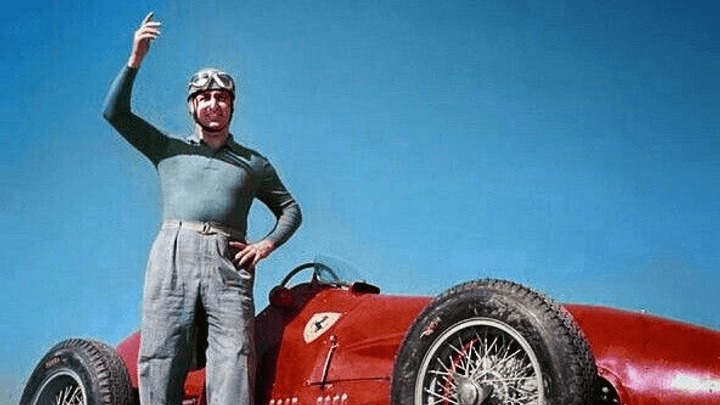 Alberto Ascari debout à côté de sa Ferrari rouge de Formule 1 des années 1950