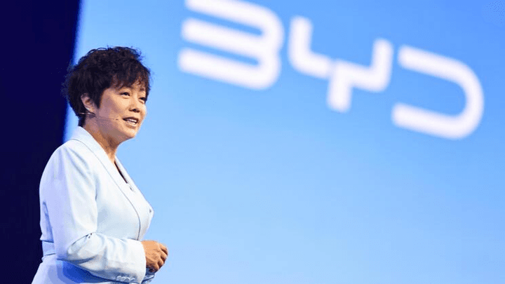 Conférence avec intervenant asiatique devant logo d'entreprise technologique