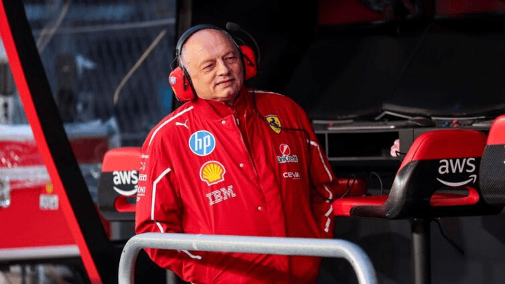 Membre de l'équipe Ferrari en combinaison rouge avec casque audio dans le garage F1