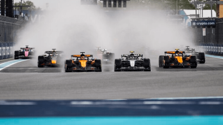 Voitures de Formule 1 en course sous la pluie sur le circuit de Miami avec gerbes d'eau