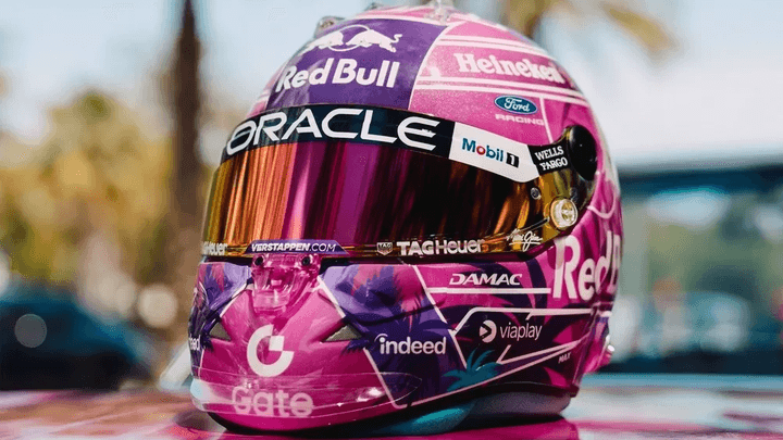Casque F1 Red Bull Racing avec livrée rose et violet, sponsors Oracle et Heineken visibles