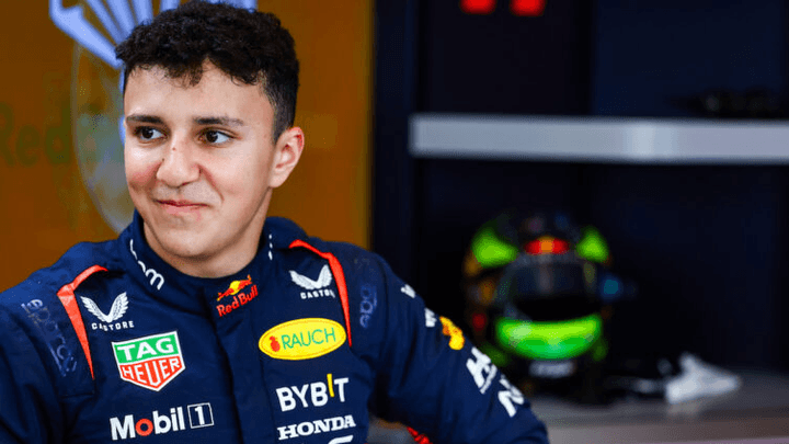 Pilote Red Bull Racing en combinaison équipe dans le paddock F1 avec monoplace en arrière-plan