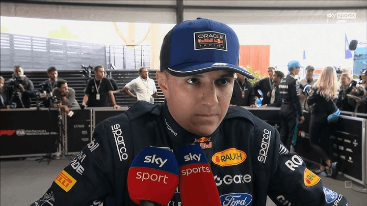 Pilote F1 en interview avec casquette Oracle Red Bull Racing dans le paddock