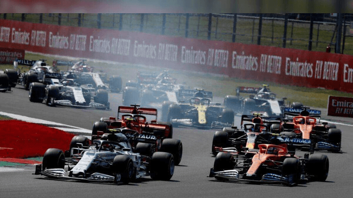 Départ de course de Formule 1 avec plusieurs monoplaces en action sur le circuit