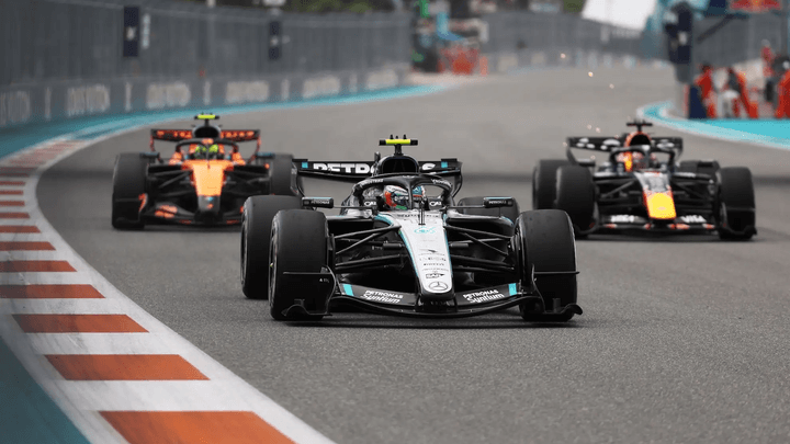 Voitures de Formule 1 en course avec une Mercedes au premier plan suivie par des concurrents
