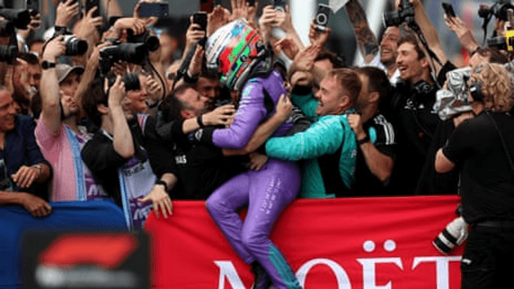 Andrea Kimi Antonelli célèbre sa victoire en F1 avec le drapeau italien, soulevé par une foule de supporters